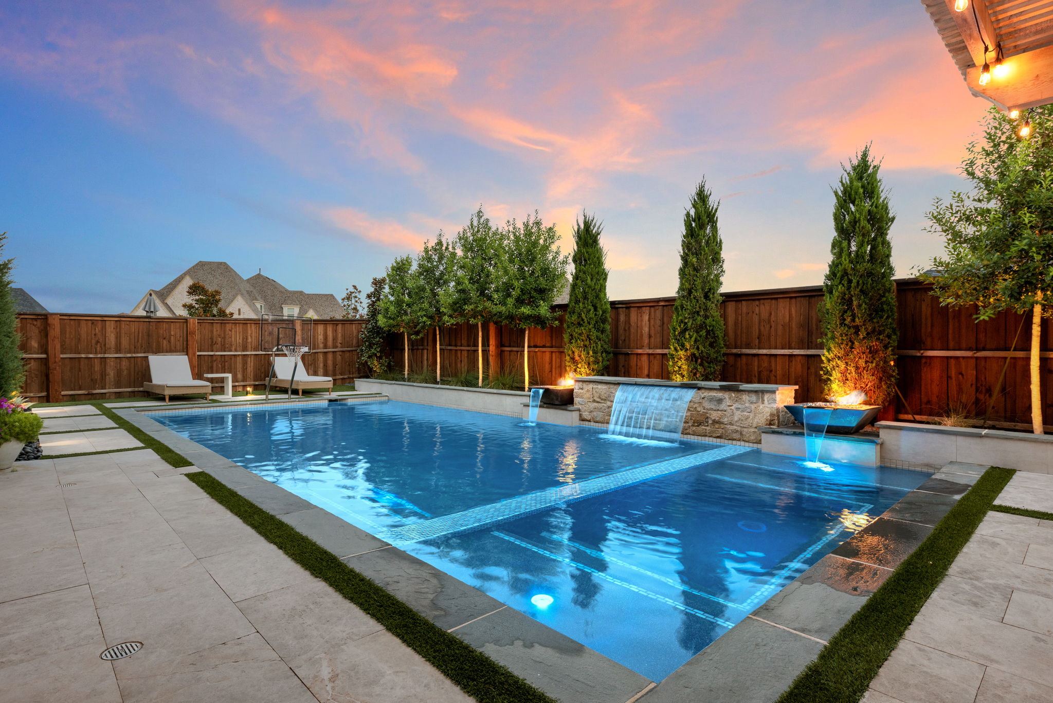 Swimming pool at sunset with fire features